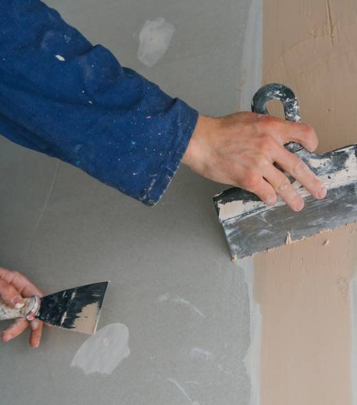 plasterer-man-works-plastering-two-trowels-plasterboard-blue-uniform plasterer-man-works-plastering-two-trowels-plasterboard-blue-uniform
